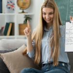 Woman sitting on couch holding a clipboard with notes.